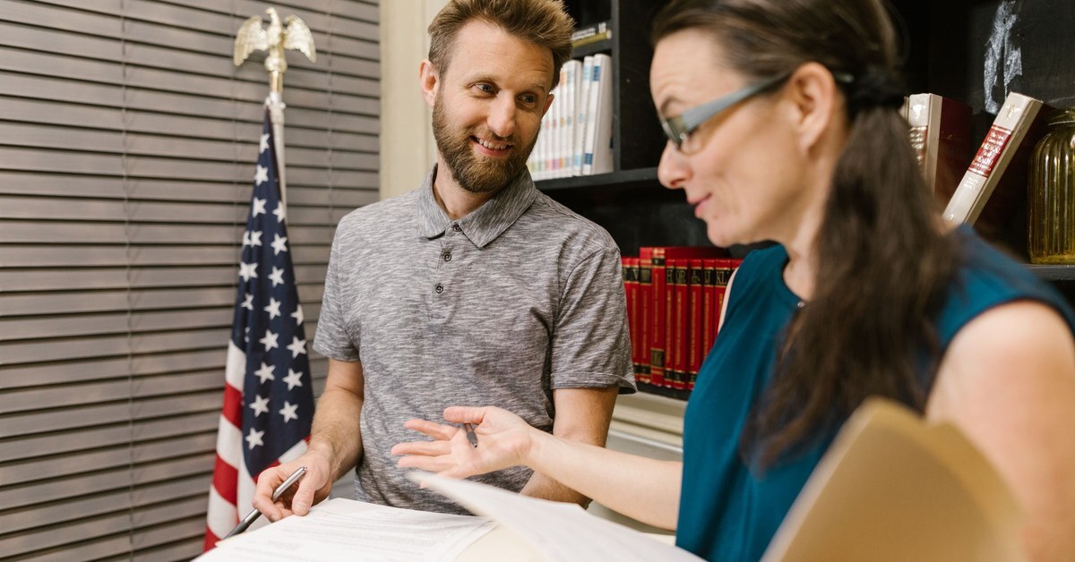 Two colleagues reviewing documents beside a US flag, like public agency staff comparing a software purchasing agreement