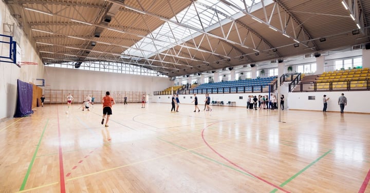 Indoor gym with several groups sharing the court at once, the kind of shared space that needs clear booking rules