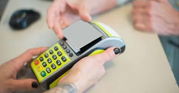 Hands entering a card payment on a handheld payment terminal