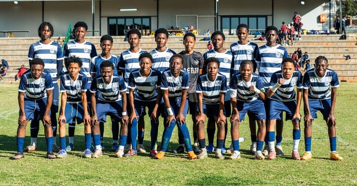 Youth soccer team in matching blue striped uniforms posing together on a field, the kind of team a local sponsor outfits