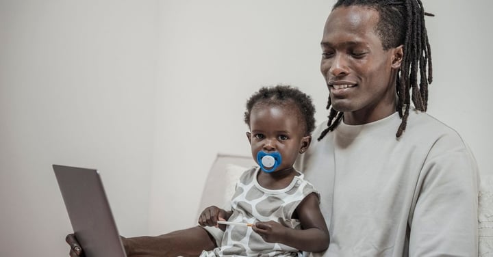 Father and toddler looking at a laptop together at home, the online sign-up experience registration software gives families