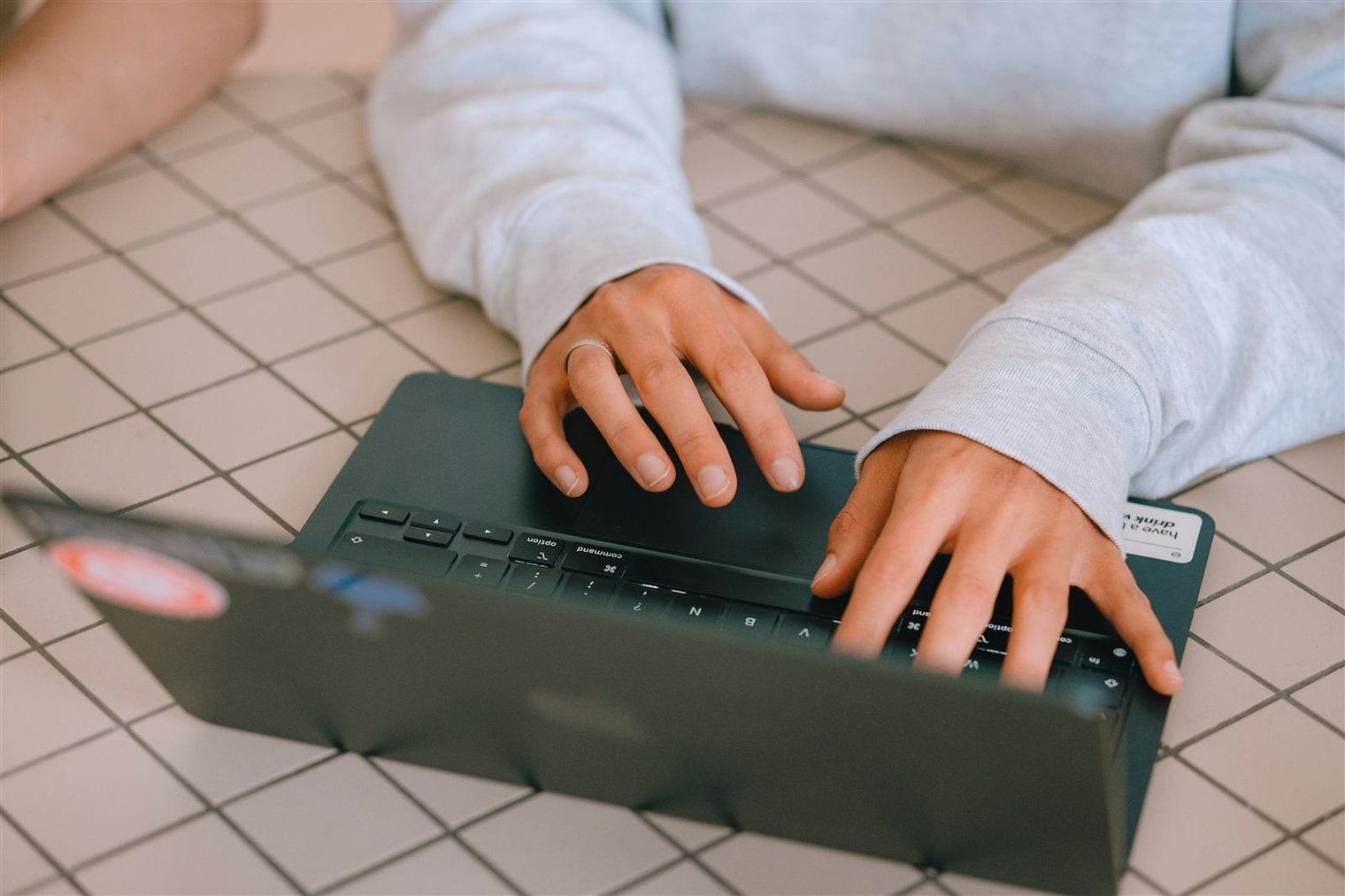 Staff member surrounded by multiple open laptops and binders, overwhelmed expression