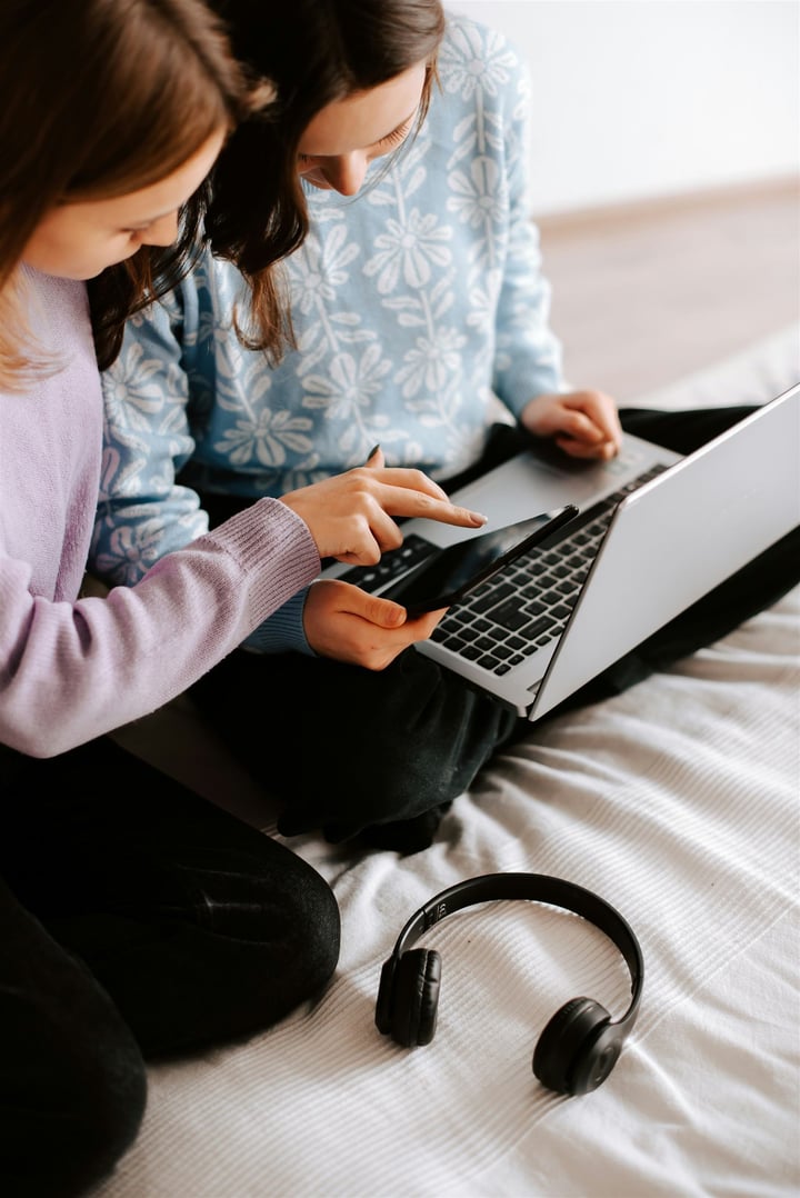 Person completing a registration on a smartphone while seated with a laptop