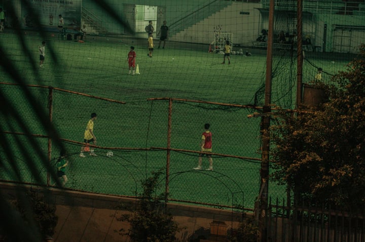 Youth soccer players practicing on an illuminated field at night.