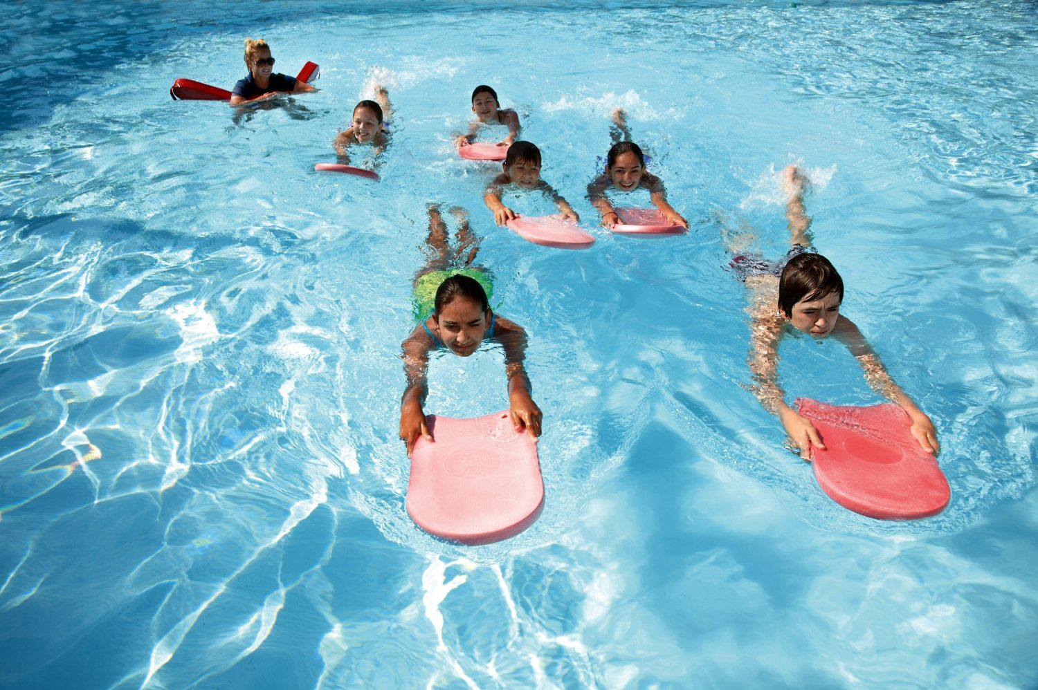 Children in a swim class at a community pool