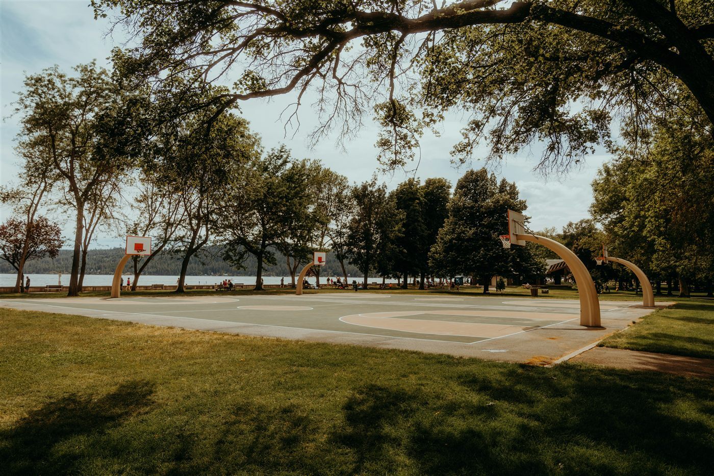 Empty outdoor basketball court beside a lake