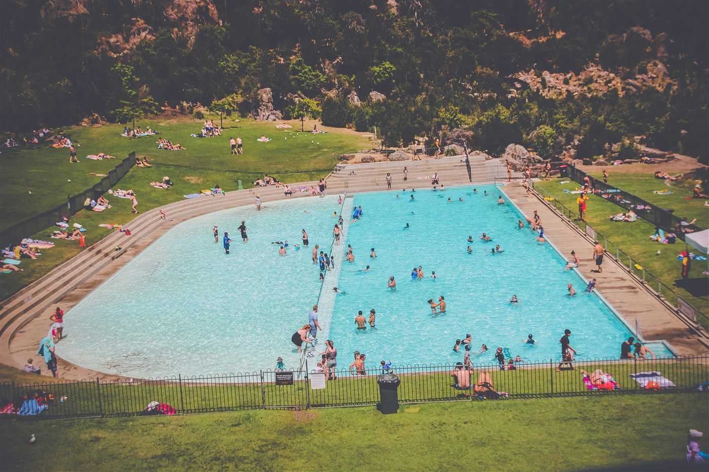 Outdoor community pool filled with swimmers