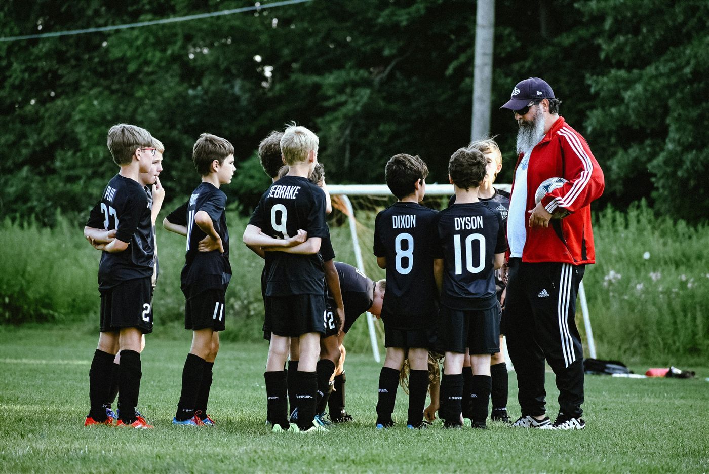 Youth soccer coach instructing players on the field