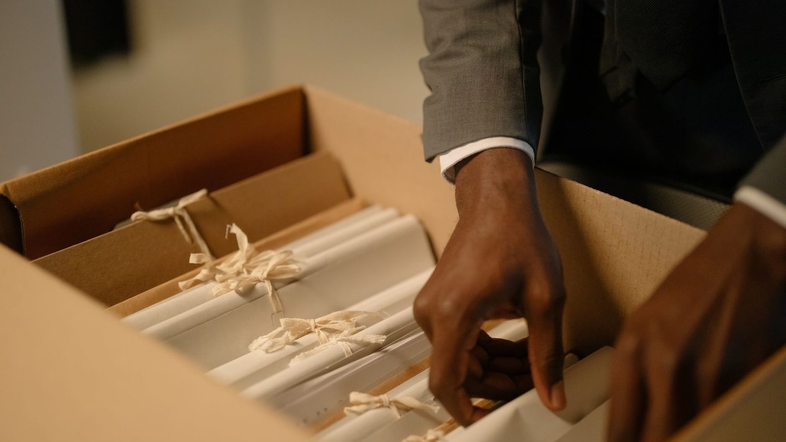Hands sorting through a box of filed records